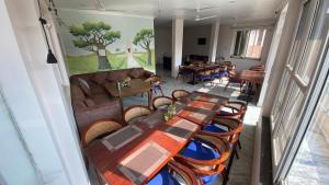 una habitación con mesas y sillas y un sofá en Soni's Mansion-800m from Khajuraho Temples, en Khajurāho