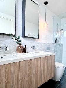 The Ebb Luxury Retreat - Just steps to the beach! في أوشن غروف: حمام مع حوض ومرحاض ومرآة +15 صورة