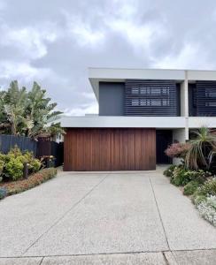 The Ebb Luxury Retreat - Just steps to the beach! في أوشن غروف: منزل فيه باب خشبي وممر