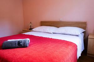 a bed with a red blanket and white pillows at Nina in Split