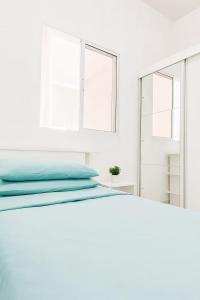 a white bedroom with a bed and a mirror at Doce Lar 58-Casa de Hóspedes in Cabo de Santo Agostinho