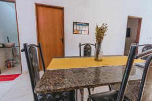 a dining room table with a vase of flowers on it at Doce Lar São Francisco in Cabo de Santo Agostinho