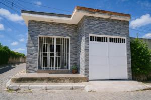 a brick house with two white garage doors at Doce Lar 58-Casa de Hóspedes in Cabo de Santo Agostinho