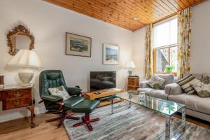 uma sala de estar com um sofá e uma TV em Market Street No 28a - St Andrews em St Andrews