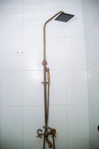 y baño con ducha y azulejos blancos. en The Hub Train House Apartments, en Zanzíbar