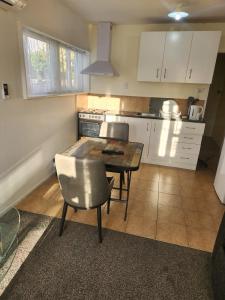 a kitchen with a table and chairs in a kitchen at Guest House Tokoroa in Tokoroa
