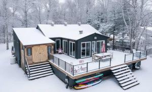 una cabaña en la nieve con esquís delante en Spa & Lake Access - Chalet OREV, en Nominingue