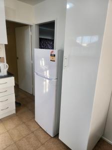 a kitchen with a white refrigerator in a room at Guest House Tokoroa in Tokoroa +16 photos