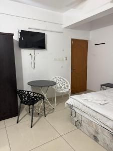 1 dormitorio con mesa, cama, mesa y silla en highland, en Kochi