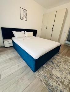 普洛耶什蒂Real Resort的卧室内的一张床铺,配有蓝色和白色床垫