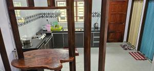 a small kitchen with a wooden chair and a table at Liya's Homestay in Kangar