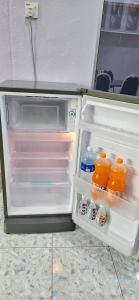 an open refrigerator filled with orange juice and milk at Liya's Homestay in Kangar