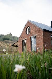 Nottingham RoadHemyock Farm Moon Cottage的砖砌的建筑,旁边是钟