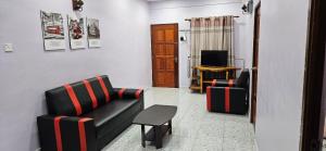 a living room with a couch and a chair at Liya's Homestay in Kangar