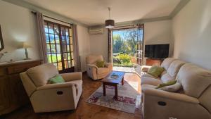 a living room with two couches and a tv at Verte Rive – Maison climatisée en bord de Dordogne in Cénac-et-Saint-Julien