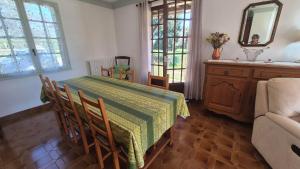 a dining room with a table and a couch at Verte Rive – Maison climatisée en bord de Dordogne in Cénac-et-Saint-Julien +12 photos