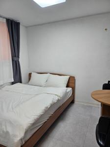 un letto in una camera con telaio in legno e tavolo di 목포 달달마실 103호 a Samgong-ni