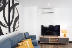 a living room with a blue couch and a tv at La Carrera 7 - La Catedral - Parking sujeto a disponibilidad in Jaén