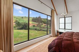 a bedroom with a large window with a view of a field at Hemyock Farm Moon Cottage in Nottingham Road