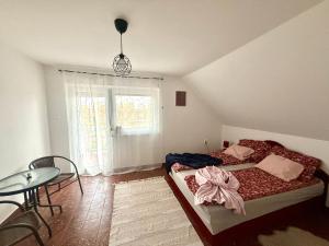 a bedroom with a bed and a table and a window at Chill & Pool Retreat Almádi in Balatonalmádi
