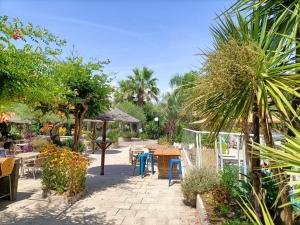 a patio with tables and chairs and plants at Luxe 6 persoons Chalet camping Leï Suves Cote d'Azur Roquebrune-sur argens in Roquebrune-sur-Argens