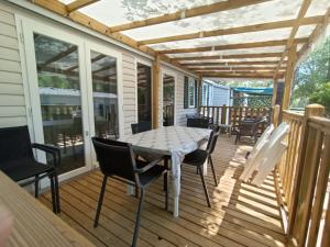 a patio with a table and chairs on a deck at Luxe 6 persoons Chalet camping Leï Suves Cote d'Azur Roquebrune-sur argens in Roquebrune-sur-Argens