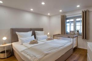 a bedroom with a large bed with two towels on it at Alpenloft mit Garten & BBQ am Chiemsee by Dollop Living in Bernau am Chiemsee