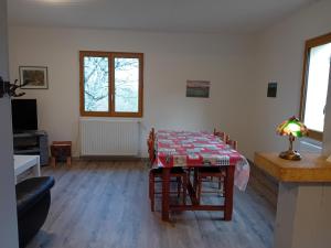 Un comedor con una mesa y sillas en una habitación. en La Bertrandie, en Florimont-Gaumiers