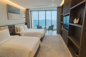 Una habitación de hotel con dos camas y un televisor. en WAVEM HOTEL East, en Siheung