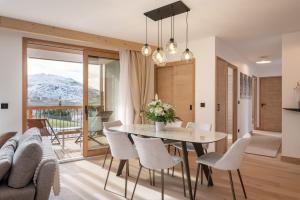 a dining room with a table and chairs and a couch at Apartment Cumbre Alpe d'Huez - by EMERALD STAY in LʼHuez