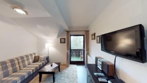 a living room with a couch and a large flat screen tv at Apartment Kärntnerhaus I in Patergassen