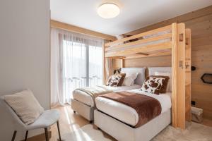 a bedroom with a bed and a chair at Apartment Cumbre Alpe d'Huez - by EMERALD STAY in LʼHuez +36 photos