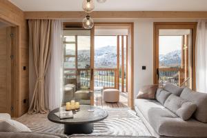 una sala de estar con un sofá y una mesa en Apartment Cumbre Alpe d'Huez - by EMERALD STAY, en LʼHuez