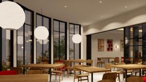 a restaurant with tables and chairs and large windows at Samai Suites in Bandar Lampung