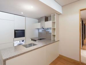 Una cocina con gabinetes blancos y un fregadero. en Grand Mercure Ambassador Hotel and Residences Seoul Yongsan, en Seúl