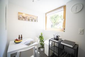 a small white room with a desk and a window at Studio Nuna EG in Ardez +14 photos