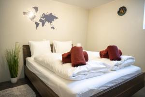 a bedroom with a bed with white sheets and brown pillows at Studio Nuna EG in Ardez