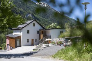 a white house in front of a mountain at Studio Nuna EG in Ardez