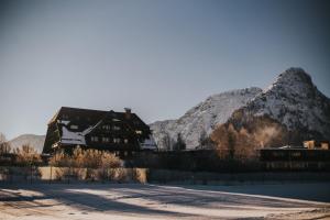 巴特奥塞G'sund & Natur Hotel Die Wasnerin - Adults Only的背景中可以看到一座白雪皑皑的山峰，以及一栋建筑。
