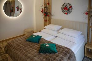 a bedroom with a bed with two green pillows on it at Wiślański Renifer in Wisła