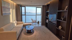 una sala de estar con un sofá y un televisor en WAVEM HOTEL East, en Siheung