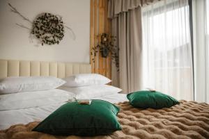 una camera con 2 cuscini verdi su un letto di Wiślański Renifer a Wisła