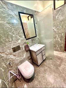 a bathroom with a toilet and a sink and a mirror at Wonderstays in Amritsar +52 photos