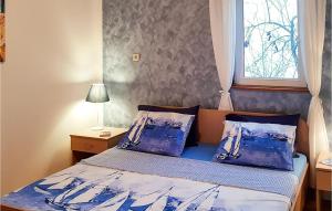 ein Schlafzimmer mit einem Bett mit blauen Laken und einem Fenster in der Unterkunft Lovely Apartment In Mali Ston With Wifi in Mali Ston