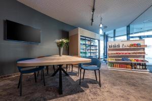 a dining room with a table and blue chairs at NH Graz City in Graz