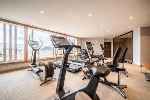 a gym with treadmills and ellipticals in front of a large window at Apartment Cumbre Alpe d'Huez - by EMERALD STAY in LʼHuez