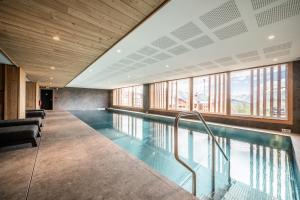 a swimming pool in a building with windows at Apartment Cumbre Alpe d'Huez - by EMERALD STAY in LʼHuez