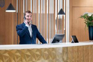 a man talking on a cell phone at a desk at NH Graz City in Graz