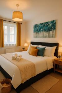 ein Schlafzimmer mit einem großen Bett, auf dem Handtücher liegen in der Unterkunft Ocean Home stay in Colchester