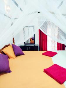 a bedroom with a large bed with purple and orange pillows at Brave resort Mirissa in Mirissa